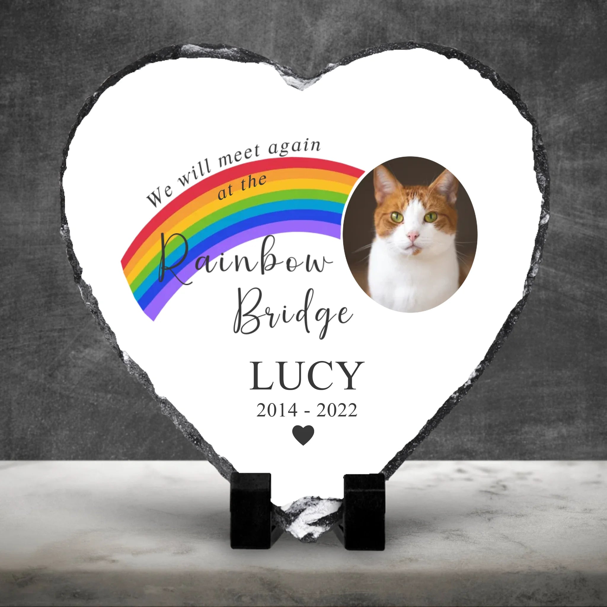 Personalised pet memorial photo slate against a dark cement wall with white marble floor