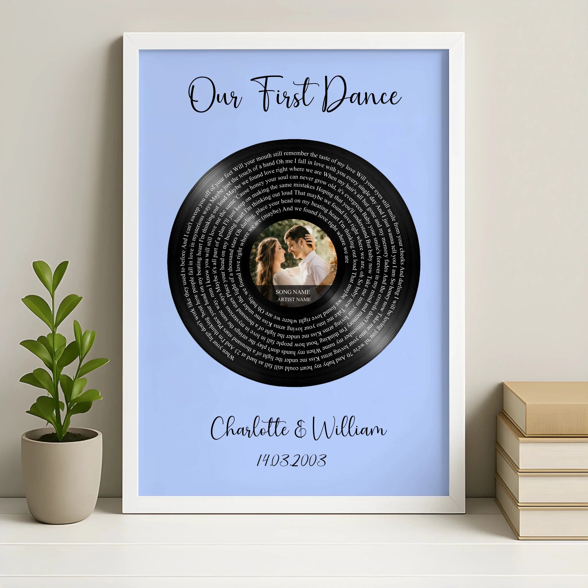 White framed Our First Dance song lyrics vinyl record print on blue, couple photo at centre, Charlotte and William, beside pl