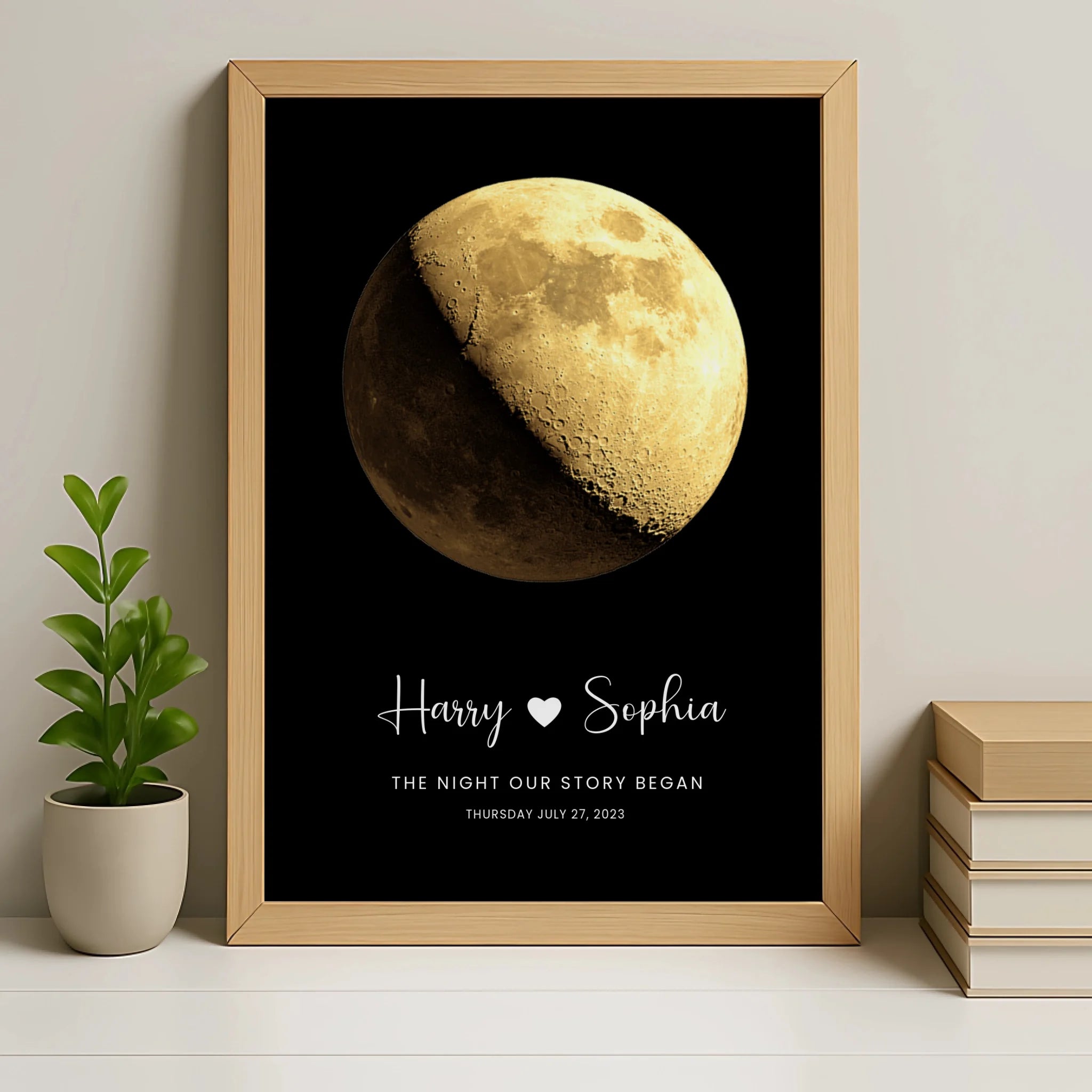 Close-up of personalised moon phase print in natural oak frame showing gold gibbous moon, Harry and Sophia with a heart, and