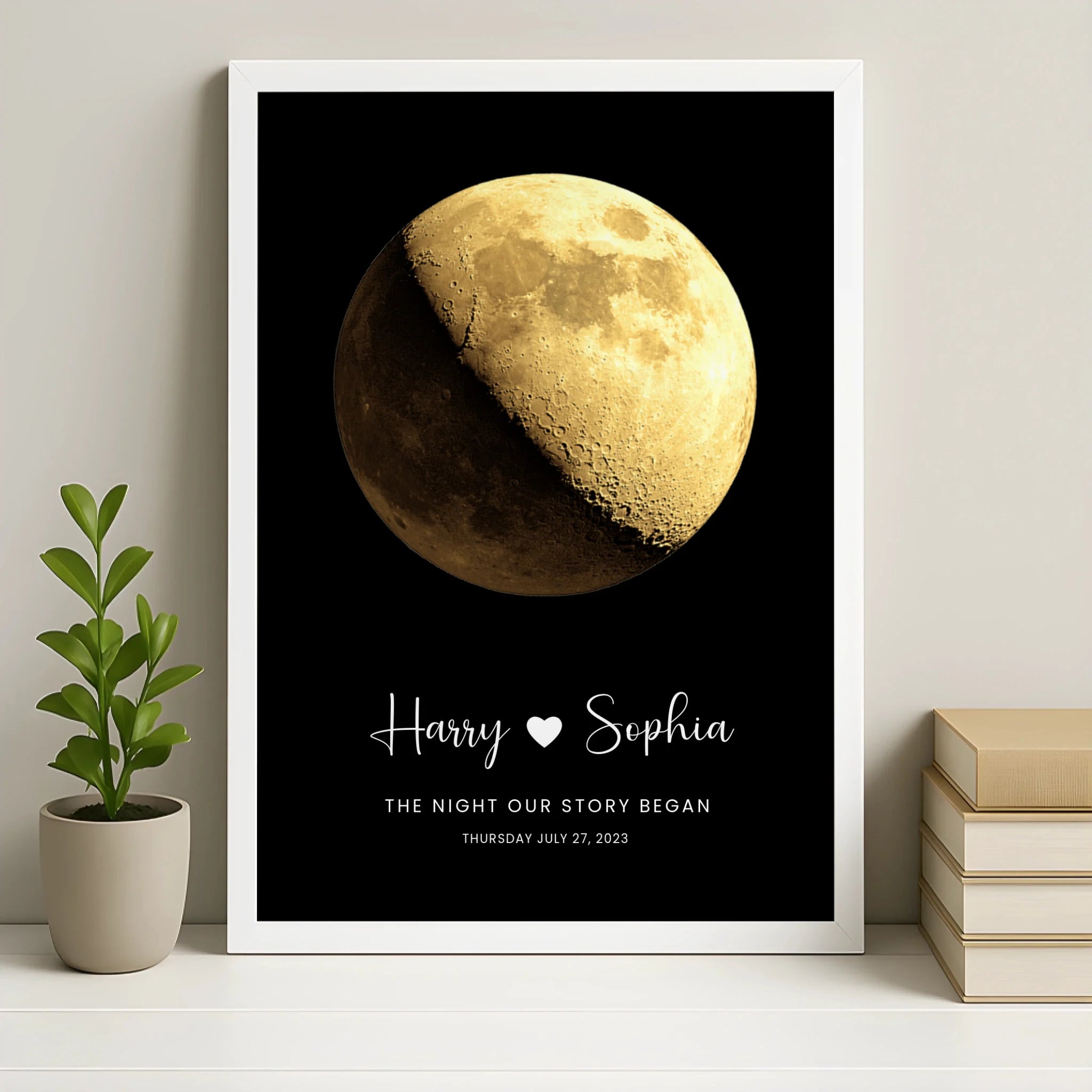 White framed personalised moon phase print for Harry and Sophia, The Night Our Story Began, July 27 2023, on shelf with small