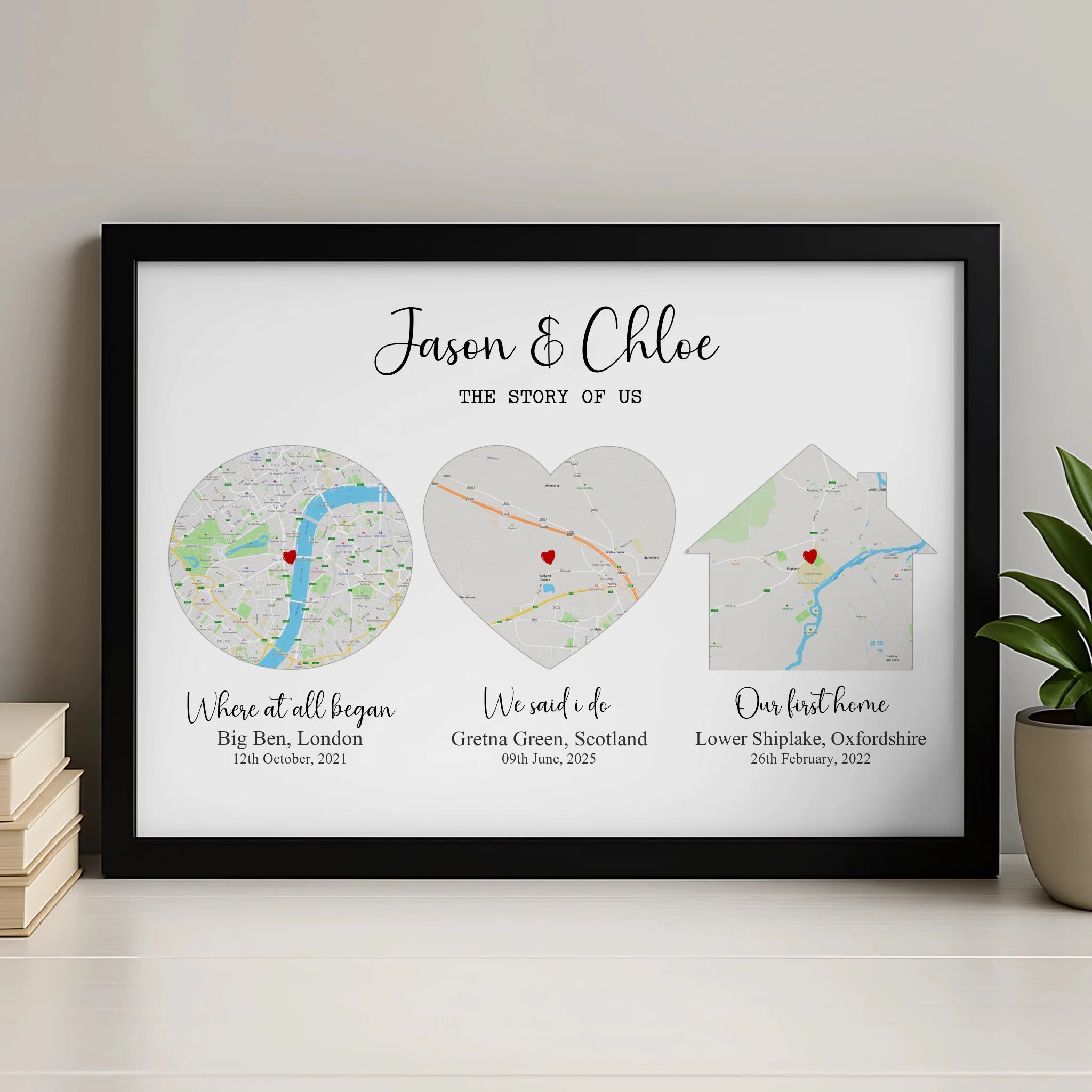 Black framed Story of Us map print for Jason and Chloe, three maps in circle, heart and house shapes, on a shelf with books.