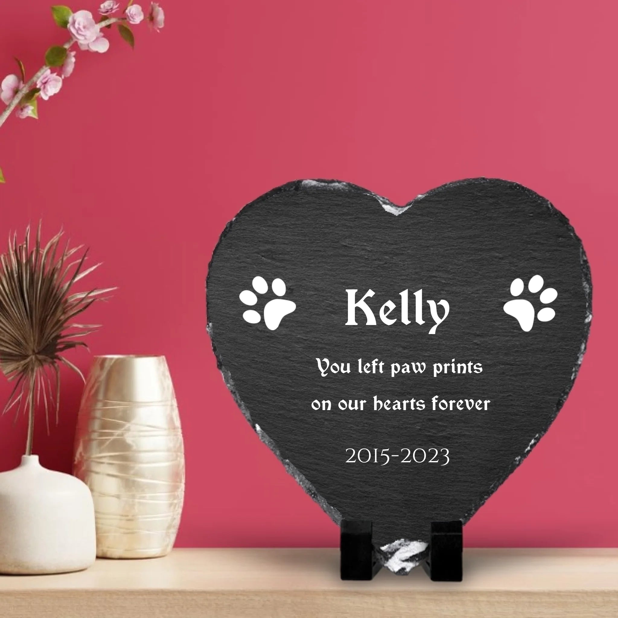 Heart shaped pet memorial photo slate displayed on a wooden shelf with pink wall panelling