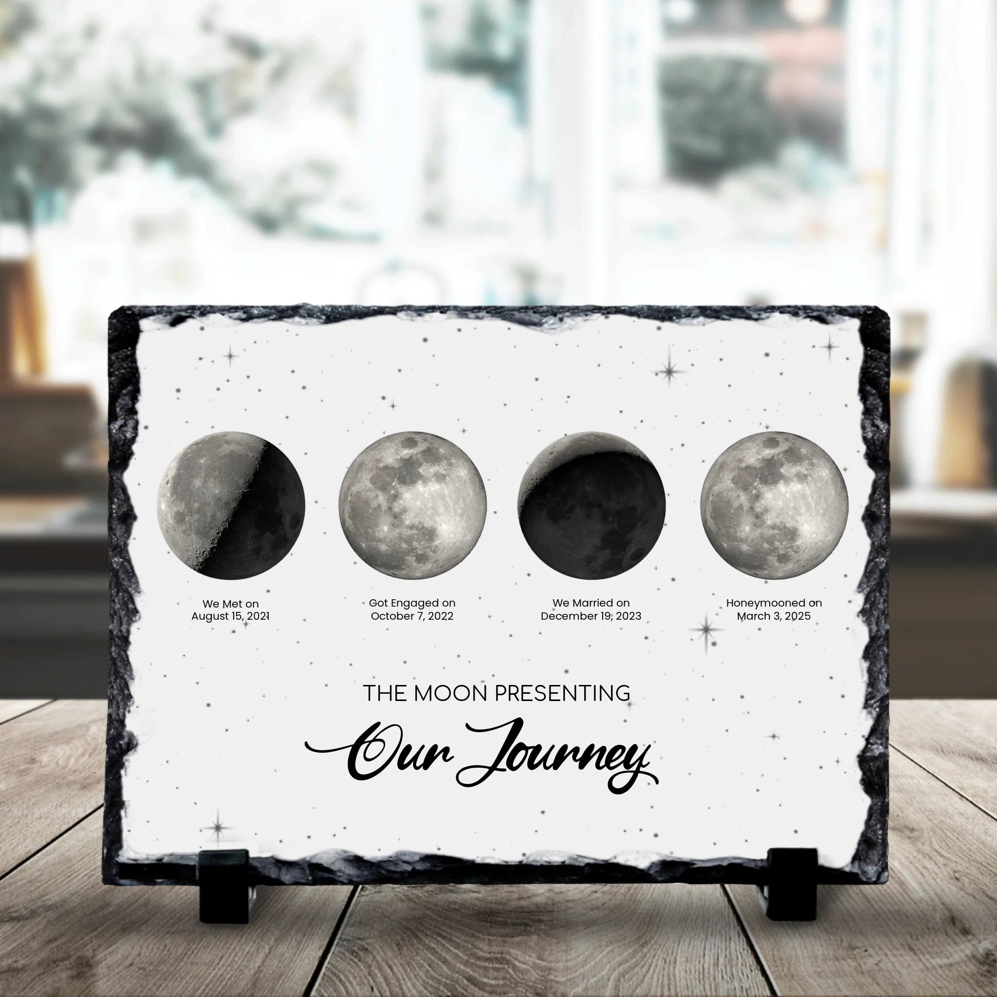 Close-up of a custom moon phase photo slate showing engraved dates and moon phase designs