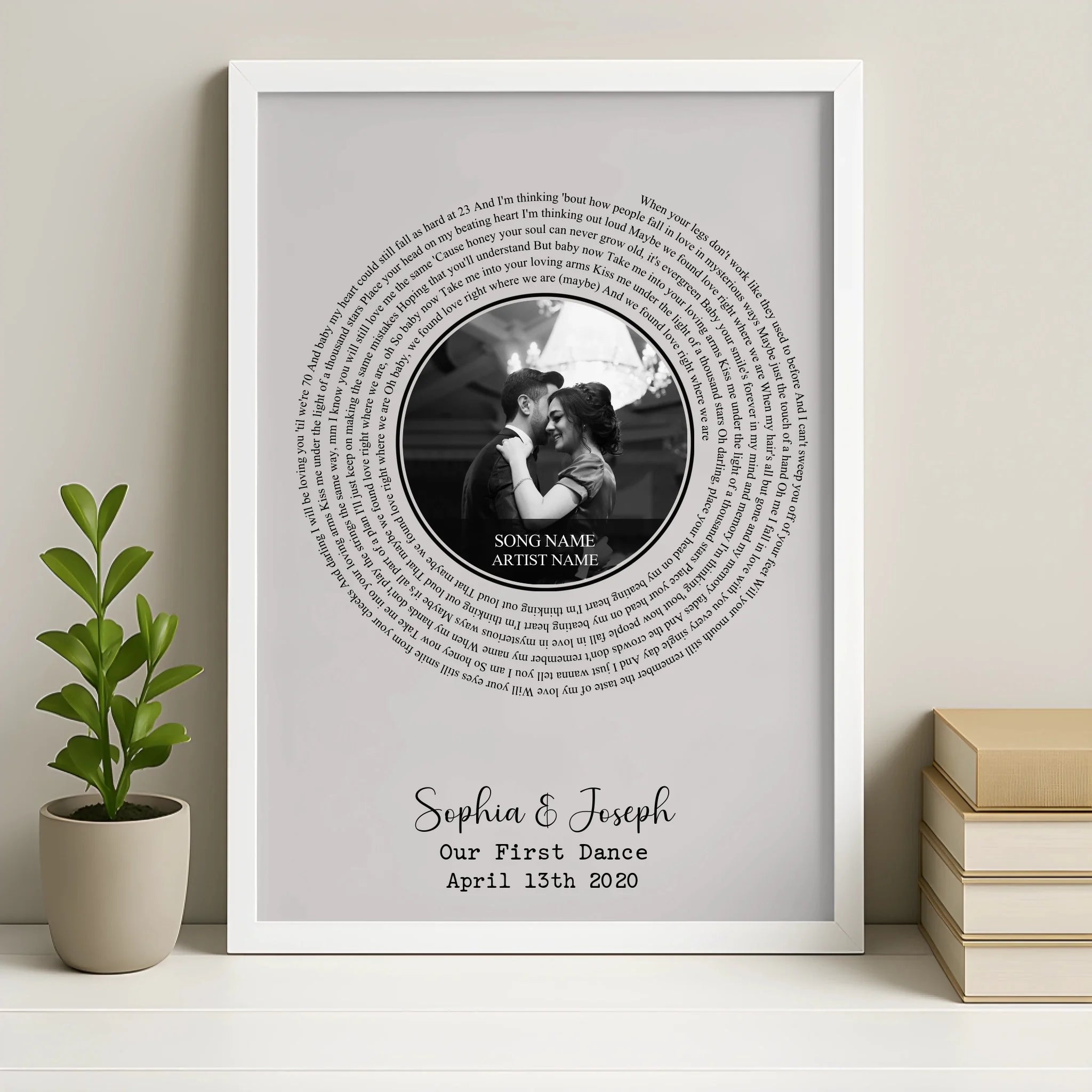 White framed spiral song lyric print on shelf with a plant and books, couple's photo centre, Sophia and Joseph, Our First Dan
