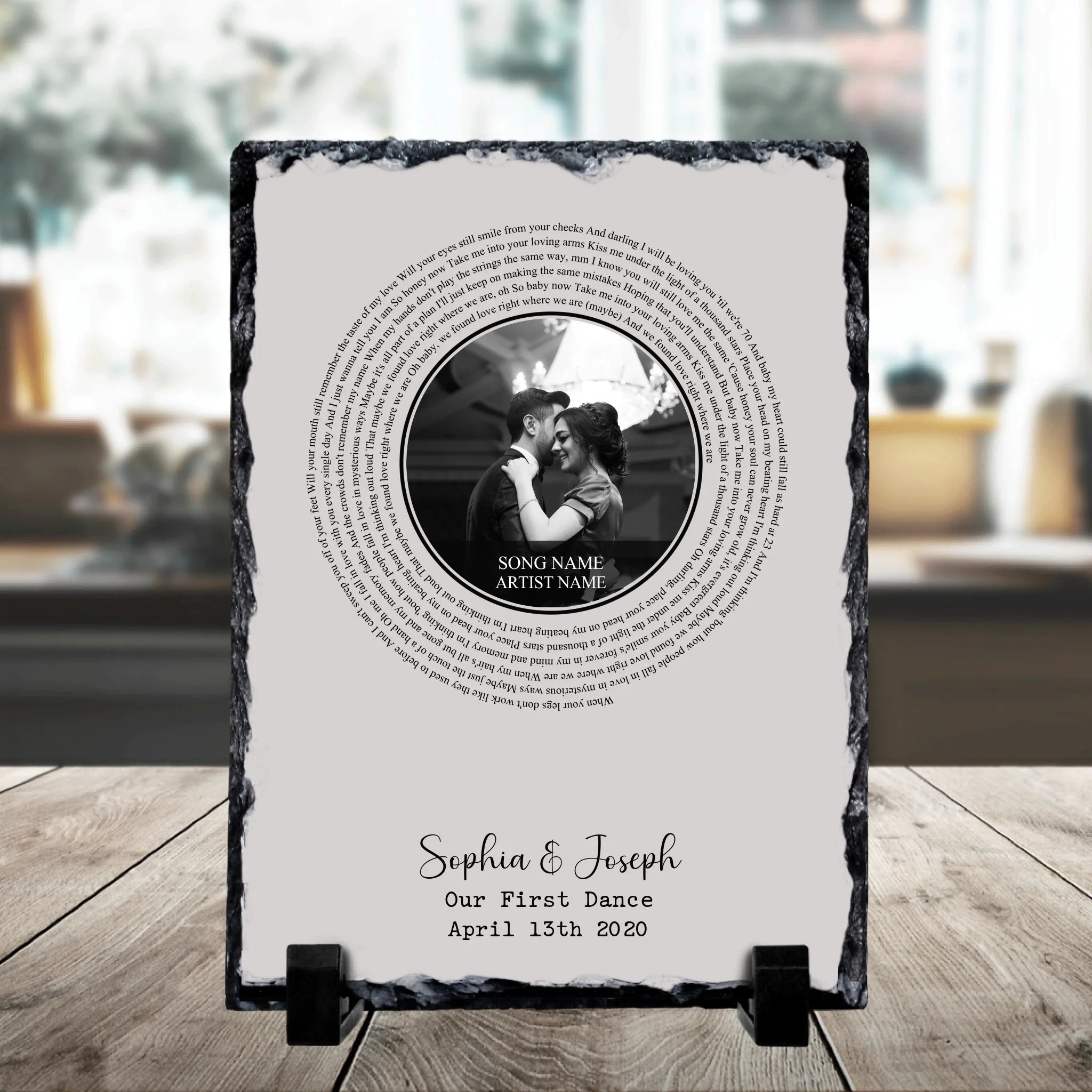 Personalised slate plaque on a stand with spiral song lyrics, a circular couple photo, and 'Sophia & Joseph, Our First Dance,