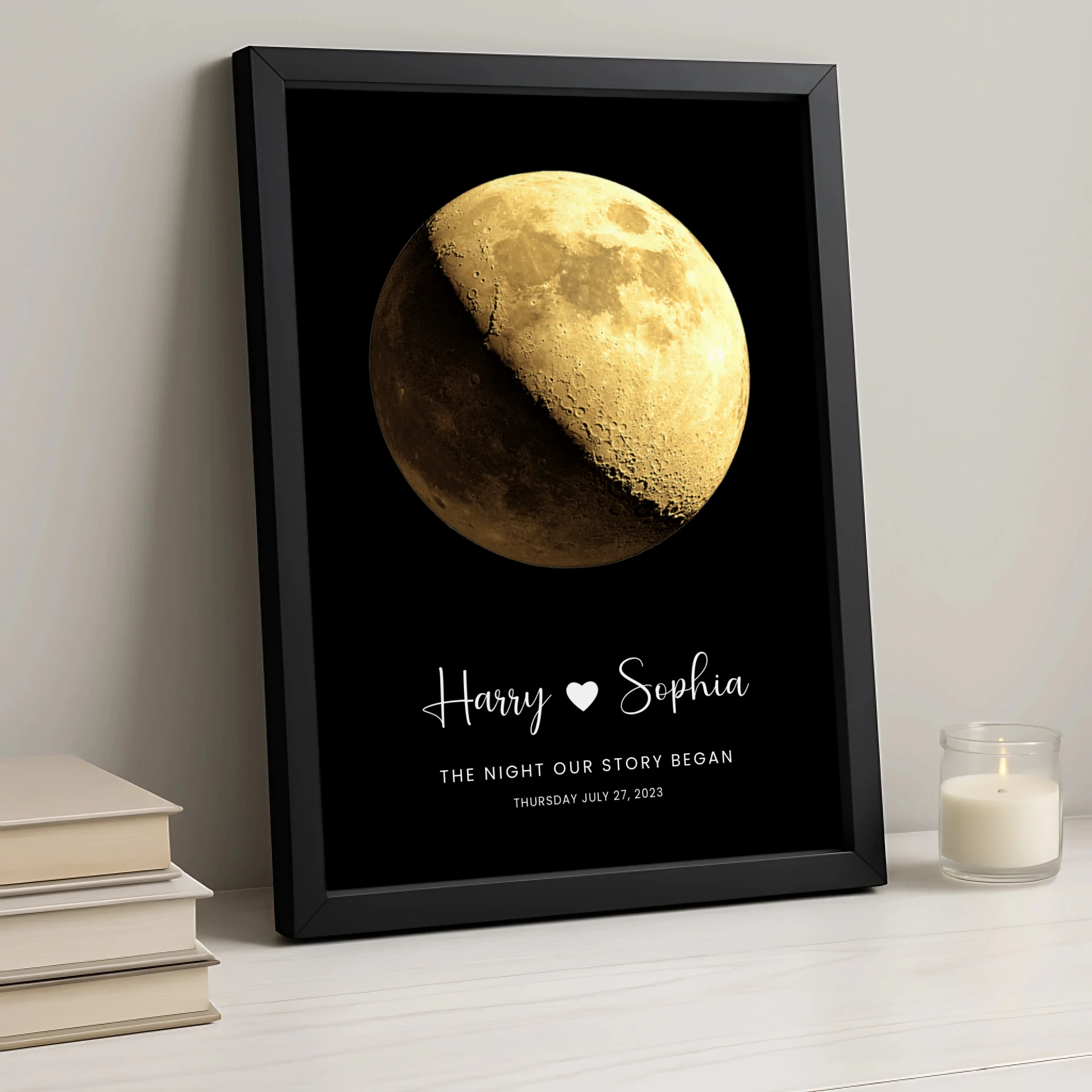 Black framed moon phase couple print reading Harry and Sophia, The Night Our Story Began, July 27 2023, displayed beside stac