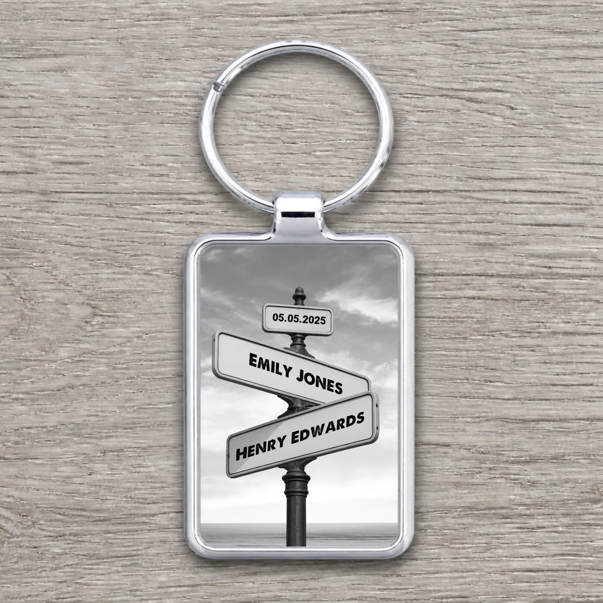 Rectangular silver keyring featuring a black and white vintage crossroads street sign personalised with Emily Jones, Henry Ed
