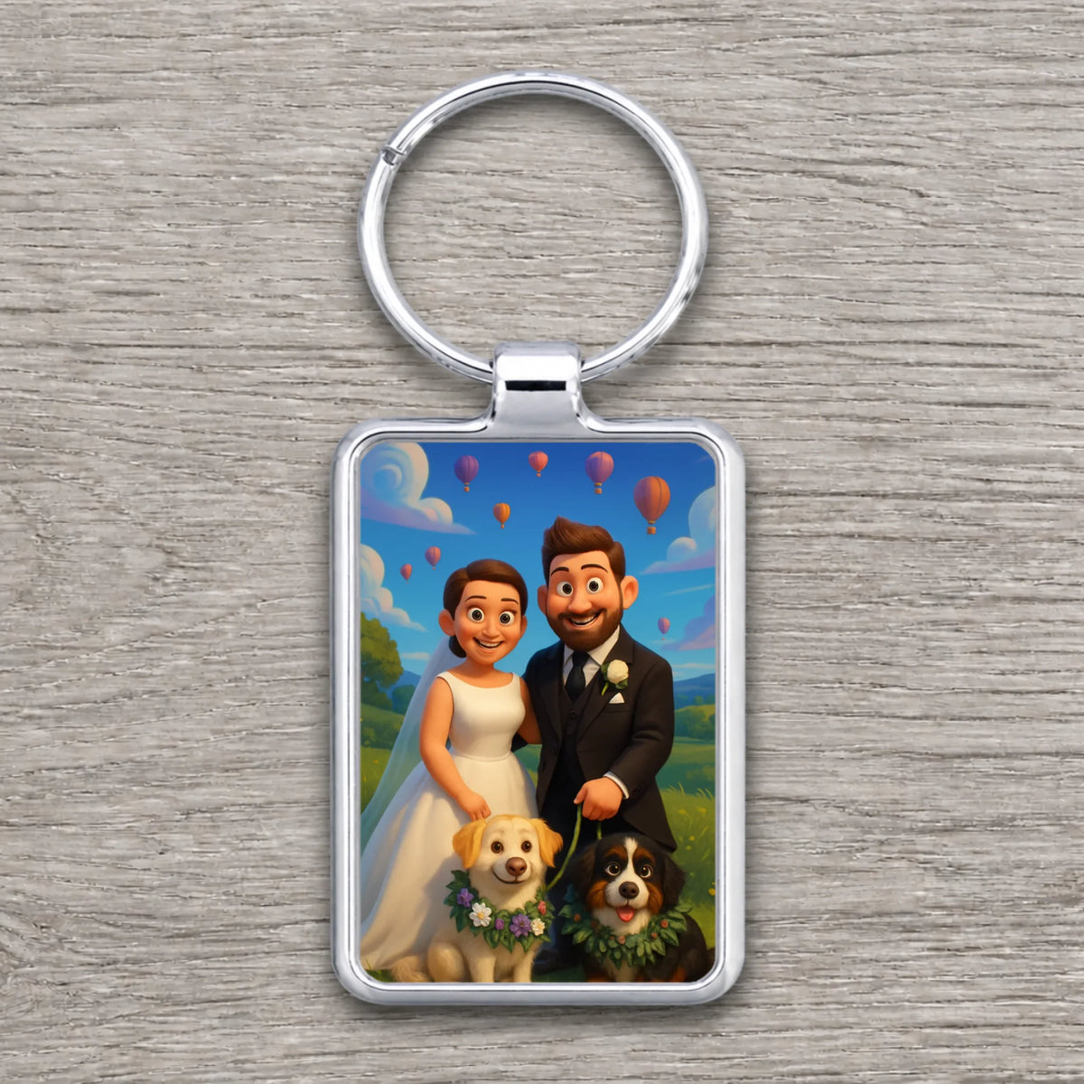 Silver rectangle keyring with cartoon animated bride and bearded groom standing with two dogs, hot air balloons in sky.