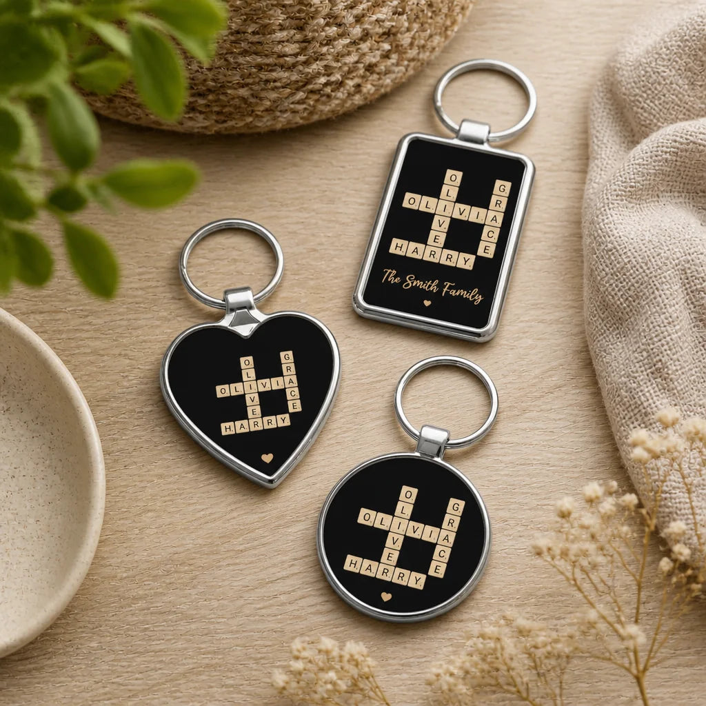 Three personalised Scrabble tile keyrings in heart, rectangle and circle shapes, black with names Olivia, Grace, Oliver, Harr
